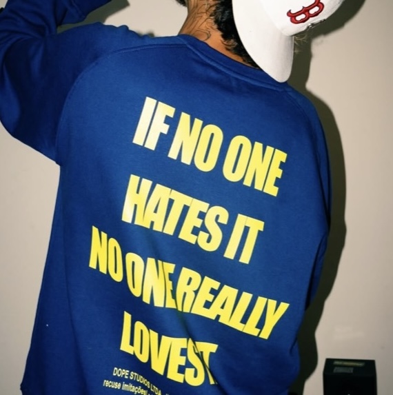 Moletom azul-marinho da Dope Tees com estampa amarela “If no one hates it no one really loves it” nas costas